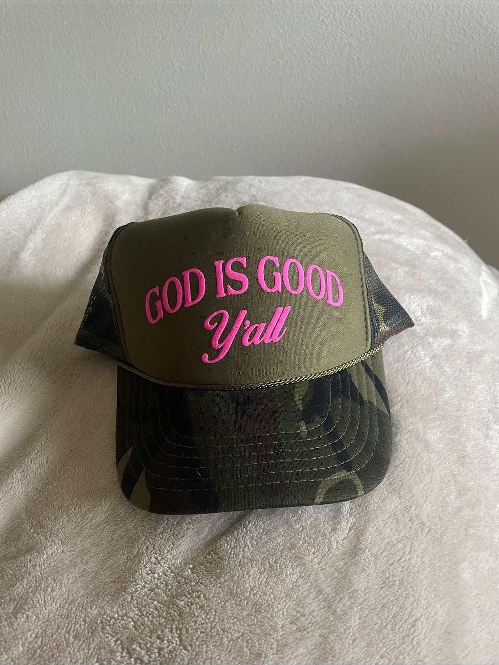 Green camo trucker hat with pink text 'GOD IS GOOD Y'all' from Texas Buc-ee’s